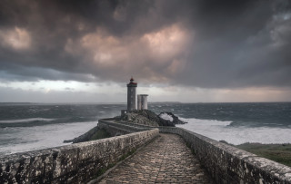Lighthouse rocky shore stormy sky - a stone path free wallpaper