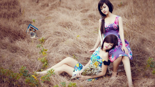 Women sitting grass field nature - two woman free wallpaper