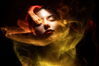 Woman blowing fire embers portrait - yellow free wallpaper