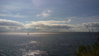 Sailboat cloudy sky lighthouse water - a light house in the distance free wallpaper