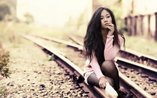 Woman sitting train track smiling - her chin free wallpaper