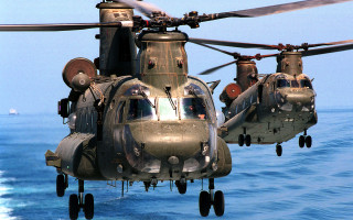 Military helicopters flying ocean sunny - a boat in the background free wallpaper
