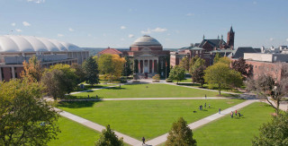 Campus view large building grassy - a grassy field in the foreground free wallpaper