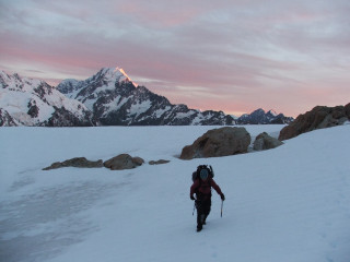 Person walking snowy hill backpack - a pink sky free wallpaper