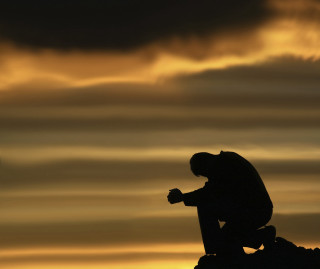 Silhouette person sitting rock sky - somber free wallpaper