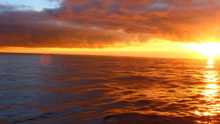 Sunset ocean boat clouds sky 3 - a sunset over the ocean free wallpaper