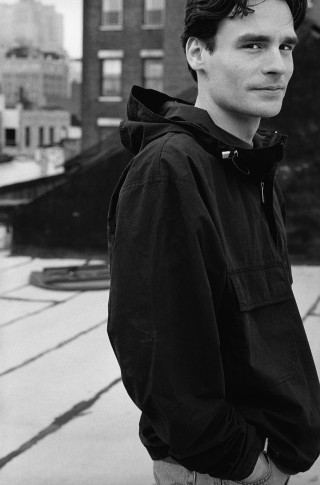 Man black jacket jeans hoodie - a city skyline in the background free wallpaper