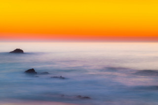Sunset ocean lighthouse yellow sky - a lighthouse in the distance free wallpaper