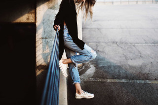Woman leaning wall hands hips 2 - claire dalby free wallpaper