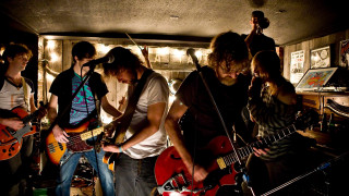 Young men playing guitars room - promotional image free wallpaper