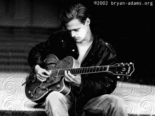 Man sitting guitar black background - his knee free wallpaper