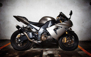 Silver motorcycle parked parking space - a white wall free wallpaper
