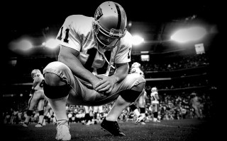 Football player kneeling field crowd - a football player free wallpaper