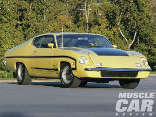 Yellow muscle car parking lot - a forest of trees and bushes free wallpaper