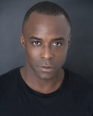 Man black shirt serious look 2 - derold page free wallpaper