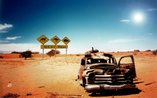 Rusted car desert road sign - apocalyptic free wallpaper