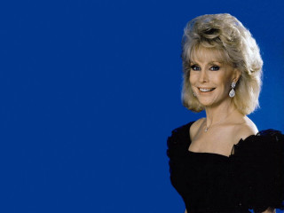 Woman black dress smiling blue - a blue background behind her free wallpaper