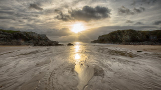 Sandy beach sunset rock outcropping - a sandy beach free wallpaper