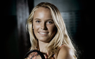 Woman holding tennis racket smiling - a tennis racket free wallpaper