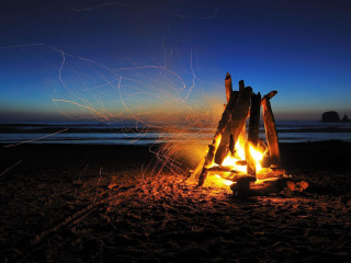 Campfire beach night blue sky - free new year wallpaper