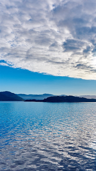 Boat water cloudy sky mountains 4 - a boat free wallpaper