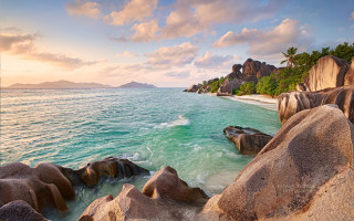 Beach rocks water mountain sunset - a colorful sky free wallpaper