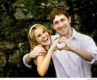 Smiling couple rockwall outdoors christmas - a picture together in front free wallpaper