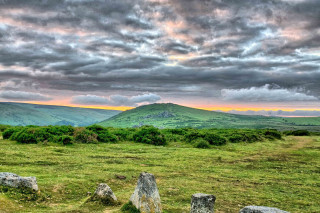 Grassy field rocks mountain cloudy - scene free wallpaper