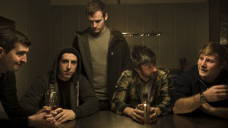 Men sitting table beer bottles 2 - one man holding free wallpaper