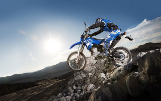 Man riding dirtbike rocky hill - action free wallpaper