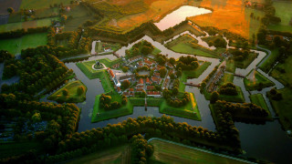 Large building river bridge forest - aerial free wallpaper