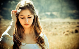 Woman field holding hair serious - a woman in a field free wallpaper