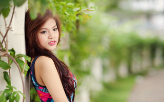 Woman leaning wall green plant 2 - a house in the background free wallpaper