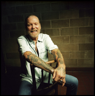 Man tattoo chair smiling camera - free portrait wallpaper