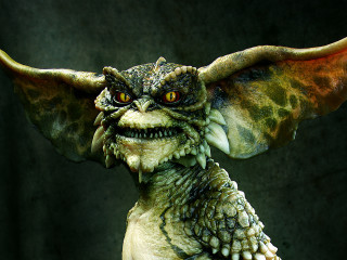Winged creature statue glowing green - a large body free wallpaper