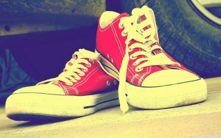 Red sneakers next to tires - free retro wallpaper