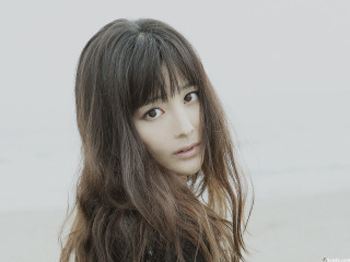 Woman long hair bangs serious - her face and shoulder free wallpaper