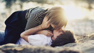 Woman kissing man beach sun - free love wallpaper