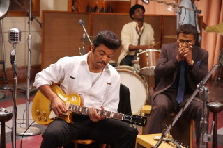 Man sitting chair playing guitar - promotional image free wallpaper