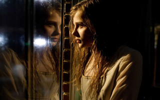 Woman looking mirror reflection self - dark shadow free wallpaper