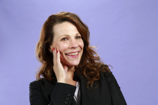 Woman smiling black jacket purple - a blue backdrop free wallpaper