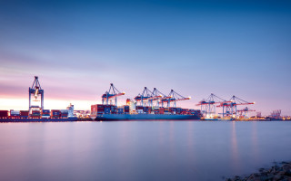 Large ship docked dock dusk - a city in the foreground free wallpaper