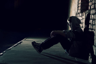 Person sitting ledgedark backpack cellphone - a person free wallpaper