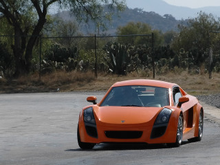 Orange sports car driving street - a mountain in the distance free wallpaper