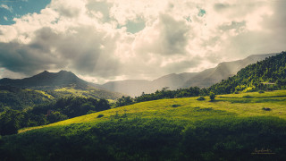 Lush green hillside cloudy sky - a cloudy sky above free wallpaper