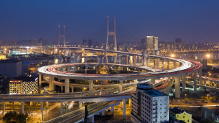 City freeway bridge nighttime lights - a city skyline in the background free wallpaper
