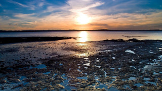 Sunset over water sky clouds - a small island in the middle of the water free wallpaper