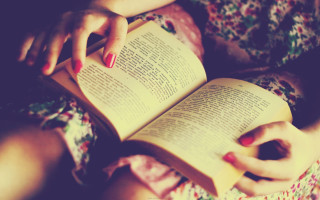 Woman reading book laying down - a book free wallpaper