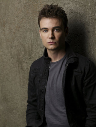 Man serious look camera aaron - a man leaning against a wall free wallpaper