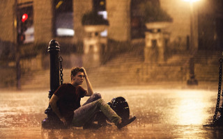 Man sitting rain hands head - his knee free wallpaper